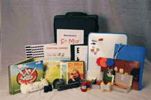 En uppackad väska med mycket saker, bland annat böcker, spel, kikare 